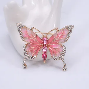 Macro shot of an elegant butterfly brooch with pink enamel wings and sparkling rhinestones