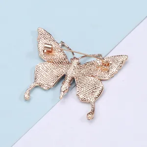 Detailed back view of champagne gold butterfly brooch with a secure rotary safety pin