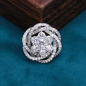 Broche fleur argentée élégante avec oxydes de zirconium sur velours bleu sarcelle