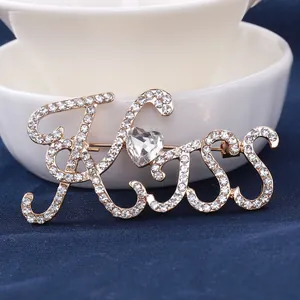 Spilla KISS dorata con strass pavé e una pietra di cristallo a forma di cuore