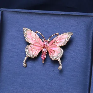 Macro shot of butterfly brooch with pink enamel wings and sparkling inlaid rhinestones