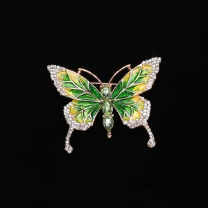 Detailed macro view of an enamel butterfly brooch with green gems and rose gold plating