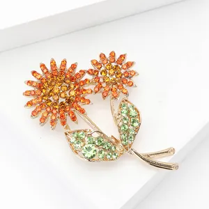 Détail de la broche tournesol en alliage doré ornée de strass orange et jaune dégradé