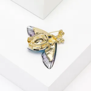 Exquisite crystal bee brooch with golden base and purple wings shown from back view