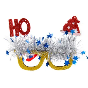 Close-up of Christmas party glasses with gold glitter frame, silver tinsel and red Santa hat