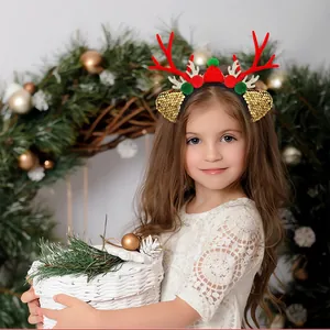 Close-up of a child wearing a Christmas reindeer antler headband with red plush balls