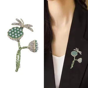 Golden dragonfly and lotus pod brooch with pearls and crystals shown on model