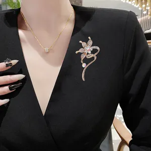 Elegant gold flower brooch with sparkling rhinestones pinned on black professional blazer
