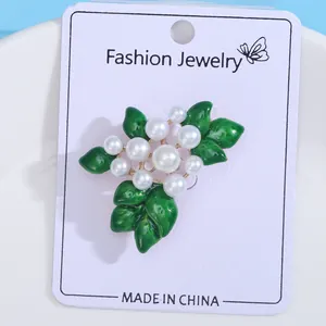 Green enamel flower leaf brooch with pearls on white retail display card