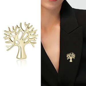 Broche en forme d'arbre dorée avec finition miroir sur un revers de blazer noir chic