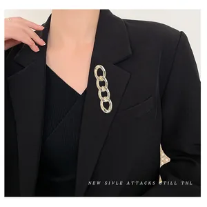 Gold chain brooch for women styled on a black blazer lapel for modern elegance
