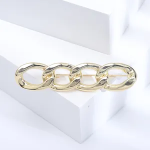 Vintage chunky gold chain link hair clip with polished metallic finish on white stand