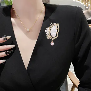 Elegant butterfly brooch with shell wings and pink pearl on a black V-neck suit jacket