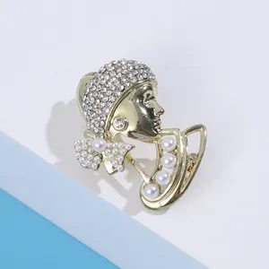 Elegant gold-tone female profile brooch with shimmering rhinestones and faux pearls