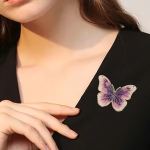Elegant violet enamel butterfly brooch with gold detailing on a black dress