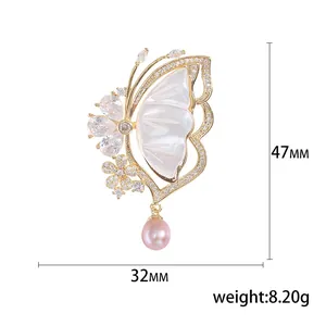 Elegant butterfly brooch with shell wings and pink pearl, measuring 32mm by 47mm