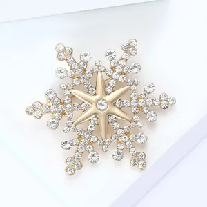 Macro shot of snowflake brooch with gold metal base and sparkling clear rhinestones