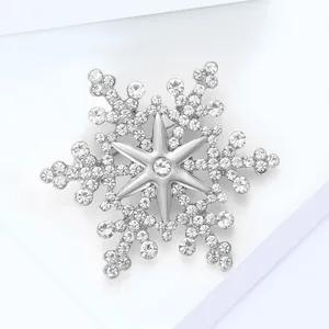 Detailed close-up of a silver snowflake brooch with sparkling inlaid rhinestones
