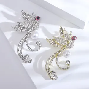 Broche phénix de luxe ornée de strass et perle blanche sur un socle minimaliste
