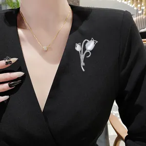 Elegante spilla a tulipano in argento con pietre opali bianche e strass lucenti sul blazer