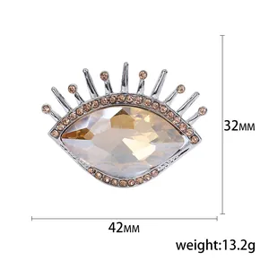 Broche œil de luxe en métal argenté avec pierre précieuse ambre et petits strass