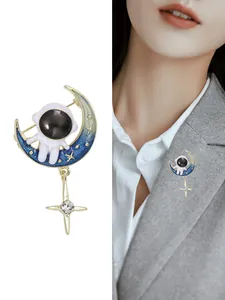 Broche astronaute sur croissant de lune bleu émaillé avec pendentif étoile dorée