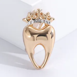 Detail of creative crown tooth brooch with gold plating and sparkling rhinestones