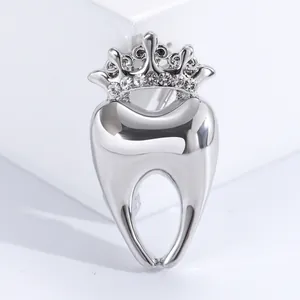Detailed macro of a polished silver tooth brooch with a sparkling rhinestone crown design