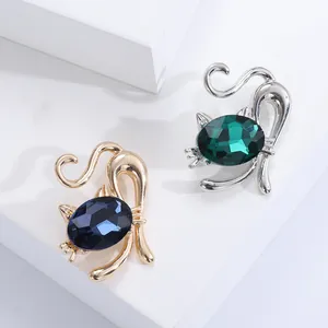 Detail eleganter Katzenbroschen in Gold und Silber mit facettierten blauen und grünen Edelsteinen