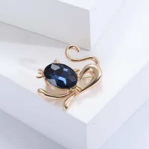 Detailansicht der Katzenbrosche mit tiefblauem Kristall und goldener Metallverarbeitung