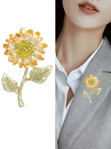 Vue détaillée de la broche tournesol avec strass jaunes et pétales émaillés sur un pull