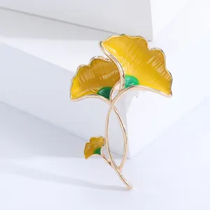 Eleganter gelb-grüner Ginkgo-Blatt-Anstecknadel in Goldoptik auf minimalistischem Display
