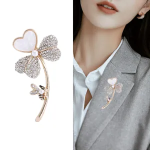 Broche trèfle dorée élégante avec nacre et abeille sur une veste de costume