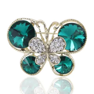 Broche papillon dorée élégante avec cristaux vert émeraude et strass blancs