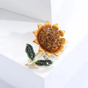 Elegant sunflower brooch featuring yellow crystals and green rhinestones on golden metal