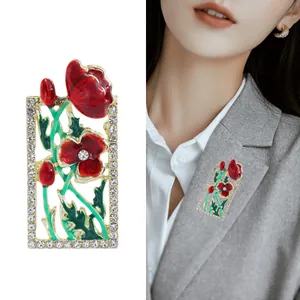 Enamel floral brooch with red poppy design and gold base on a formal gray suit blazer