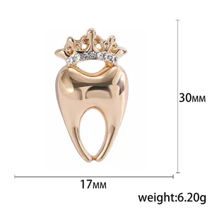 Polished gold tooth brooch with crown and rhinestones, dimensions 30mm x 17mm