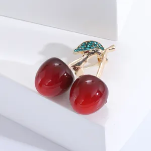Broche cerise élégante avec perles rouge foncé et cristaux verts sur tige en métal doré