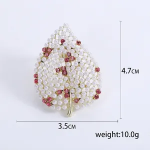 Broche feuille évidée élégante avec perles blanches et strass roses sur base dorée