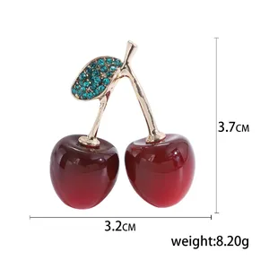 Broche cerise avec fruits en résine rouge et strass verts sur monture dorée