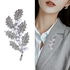 Broche feuille argentée avec perles et strass présentée sur modèle et sur fond blanc pur