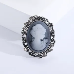 Macro shot of retro cameo brooch with vintage silver frame and sparkling rhinestones