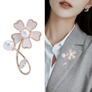 Elegant 3D shell flower brooch with pearls and crystals on a stylish grey blazer