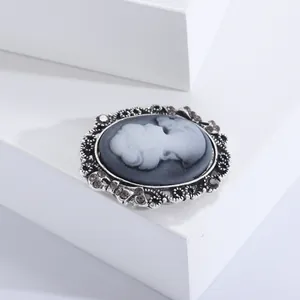 Detailed macro view of vintage cameo brooch with silver镂空 frame and sparkling crystals