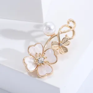 Macro shot of elegant clover brooch with mother-of-pearl petals, pearls and crystals