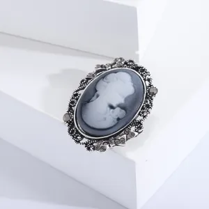 Macro shot of vintage lady cameo brooch with silver hollow lace and grey rhinestones