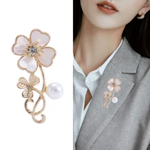 Elegant gold clover brooch with shell petals, pearl accents and sparkling rhinestones