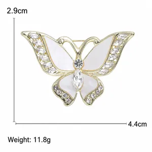 Broche de mariposa dorado con esmalte blanco y cristales, medidas 4,4 cm por 2,9 cm