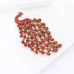 Detailed view of peacock brooch with vintage bronze alloy and sparkling red crystals