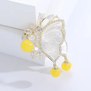 Elegant gold butterfly brooch with white mother of pearl and sparkling zircon accents